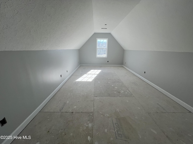 bonus room featuring lofted ceiling and a textured ceiling