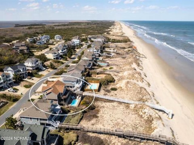 birds eye view of property with a water view and a view of the beach