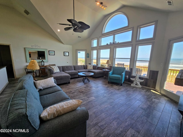 living room with a water view, ceiling fan, dark wood-type flooring, and high vaulted ceiling