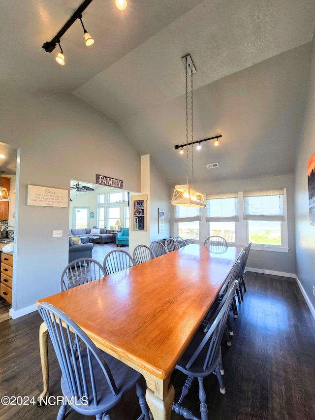 dining room featuring vaulted ceiling, ceiling fan, track lighting, and dark hardwood / wood-style flooring