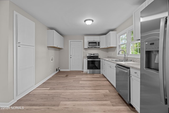 kitchen featuring white cabinetry, appliances with stainless steel finishes, sink, and light wood-type flooring