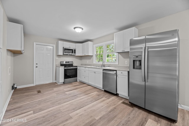 kitchen featuring light hardwood / wood-style floors, appliances with stainless steel finishes, and white cabinets