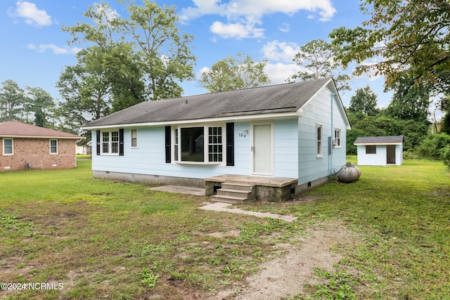 view of front of home with an outbuilding and a front lawn