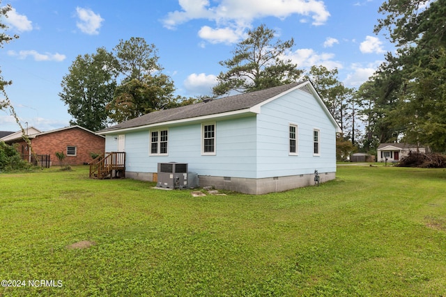 back of property featuring a yard and central air condition unit