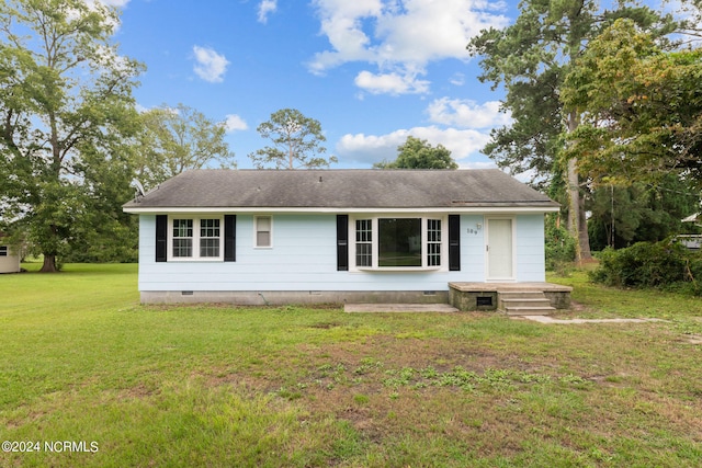 rear view of house featuring a lawn