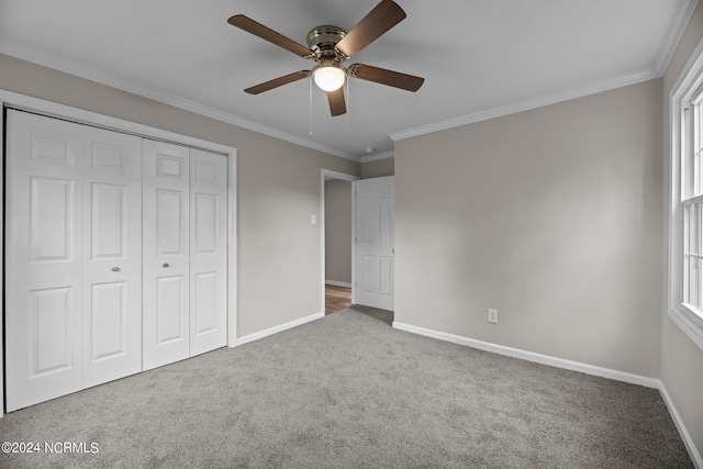 unfurnished bedroom featuring a closet, ornamental molding, carpet, and ceiling fan