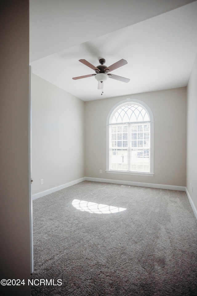 empty room with ceiling fan and light colored carpet