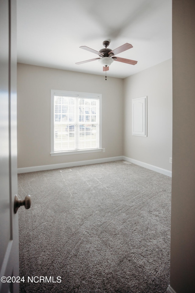 carpeted empty room featuring ceiling fan