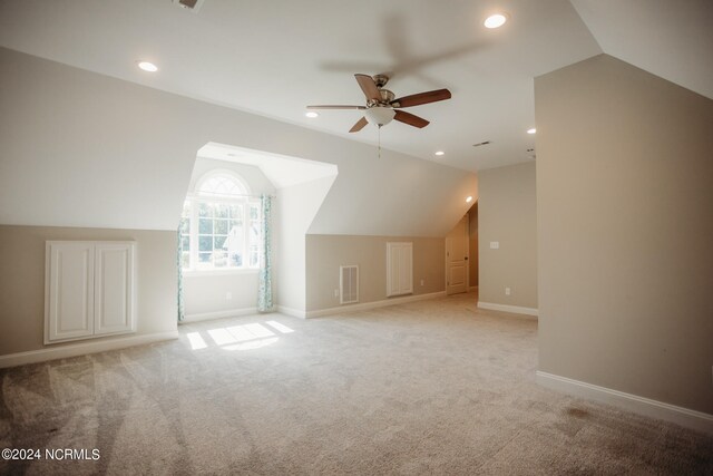 additional living space featuring lofted ceiling, light colored carpet, and ceiling fan