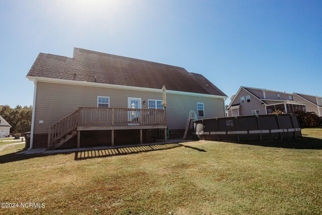 back of house featuring a lawn and a deck