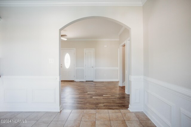 corridor with ornamental molding and light wood-type flooring