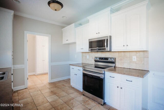 kitchen featuring appliances with stainless steel finishes, white cabinetry, and tasteful backsplash