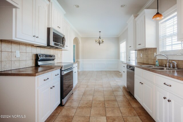 kitchen featuring stainless steel appliances, a healthy amount of sunlight, sink, and white cabinetry