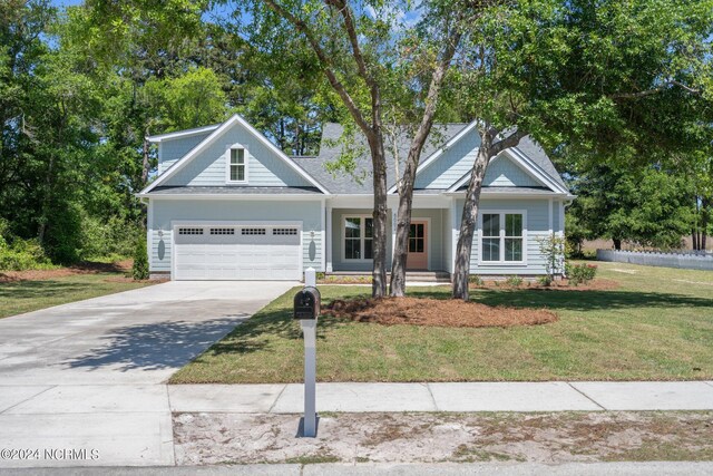 craftsman house with a front lawn and a garage