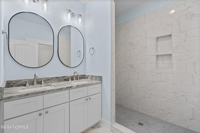 bathroom with vanity and a tile shower