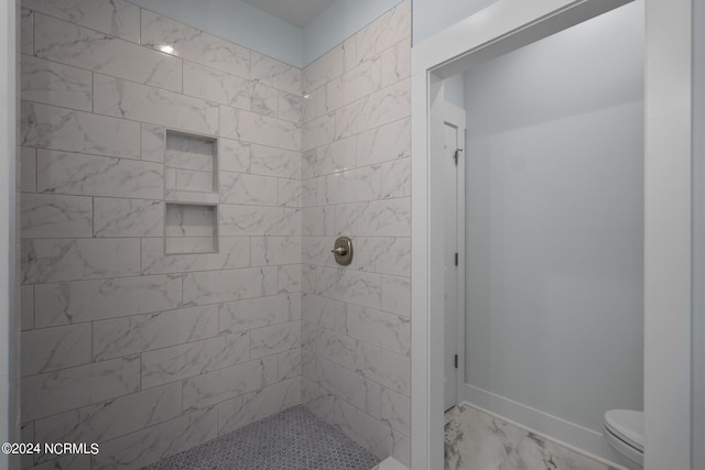 bathroom with toilet and tiled shower