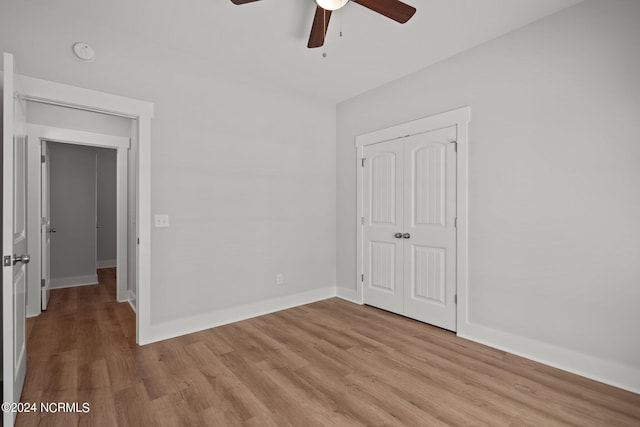 unfurnished bedroom with light hardwood / wood-style flooring, ceiling fan, and a closet