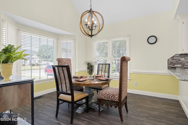 dining room featuring dark hardwood / wood-style floors, vaulted ceiling, and a chandelier