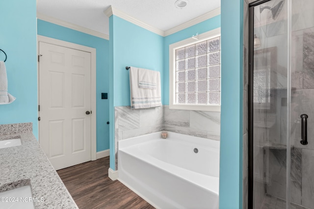 bathroom with vanity, ornamental molding, independent shower and bath, a textured ceiling, and hardwood / wood-style flooring