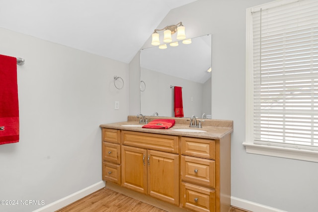 bathroom with vanity, vaulted ceiling, and wood-type flooring