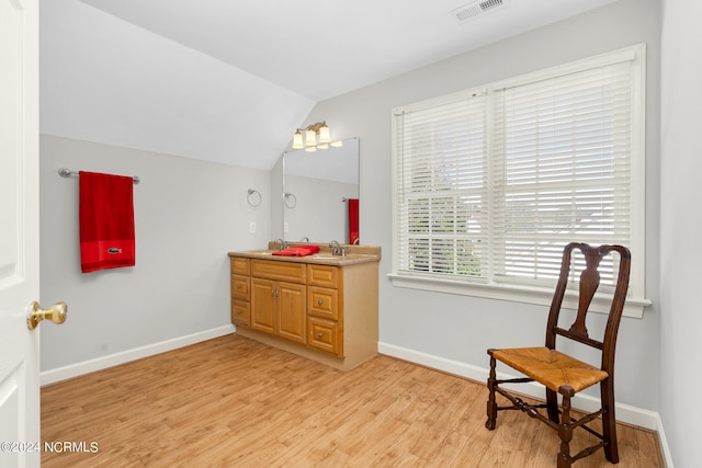 bathroom featuring lofted ceiling, hardwood / wood-style floors, and vanity