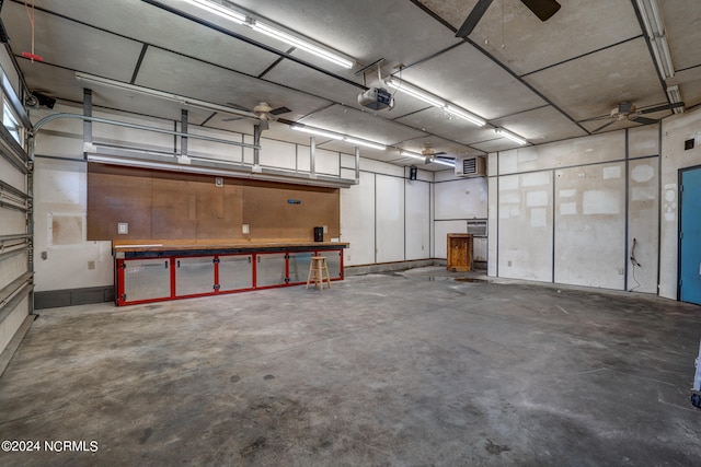 garage featuring a garage door opener, a workshop area, and ceiling fan