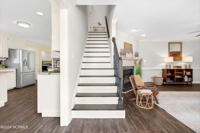 stairway featuring wood-type flooring and crown molding