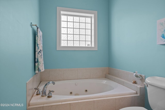 bathroom with toilet and tiled bath