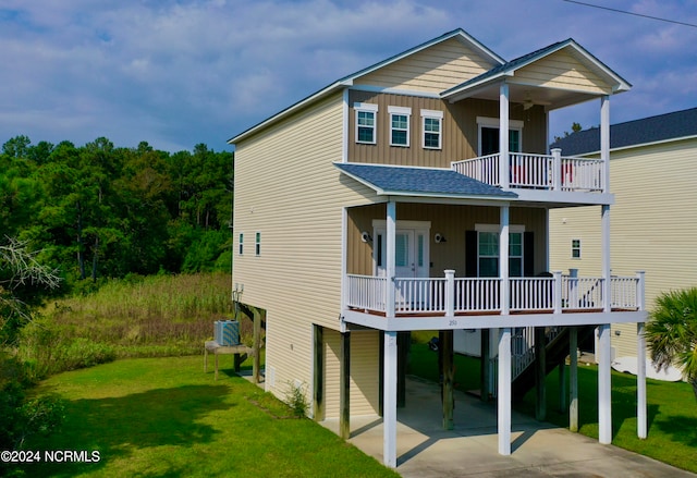 back of property featuring ceiling fan, a carport, and a yard