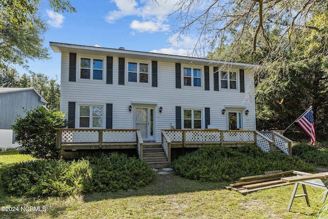 colonial house with a wooden deck and a front yard