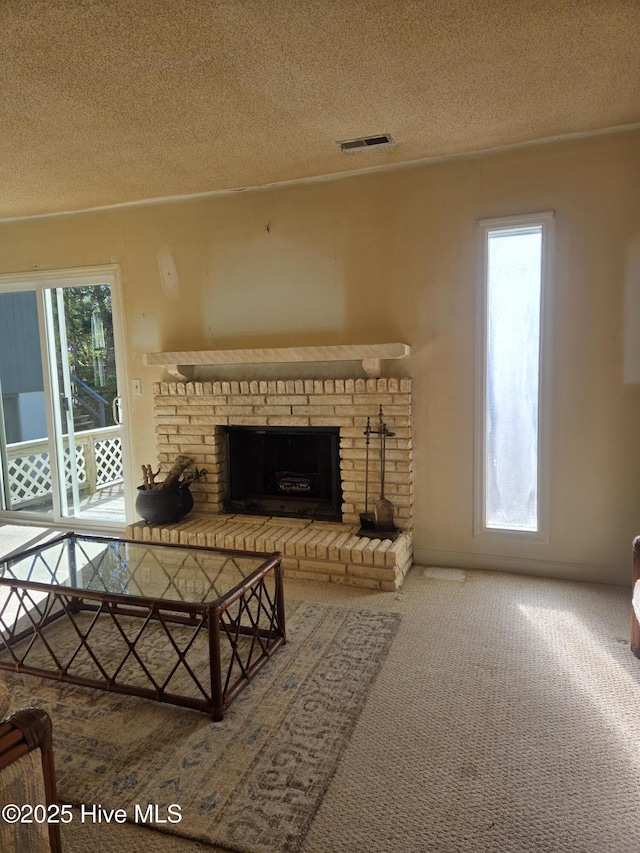 unfurnished living room featuring a brick fireplace, a textured ceiling, and carpet floors