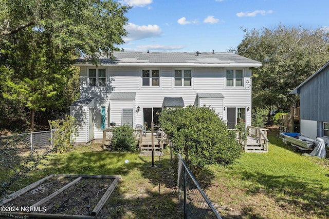 back of property featuring a deck and a yard