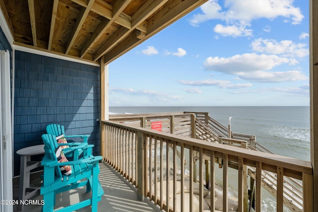 balcony with a water view and a beach view