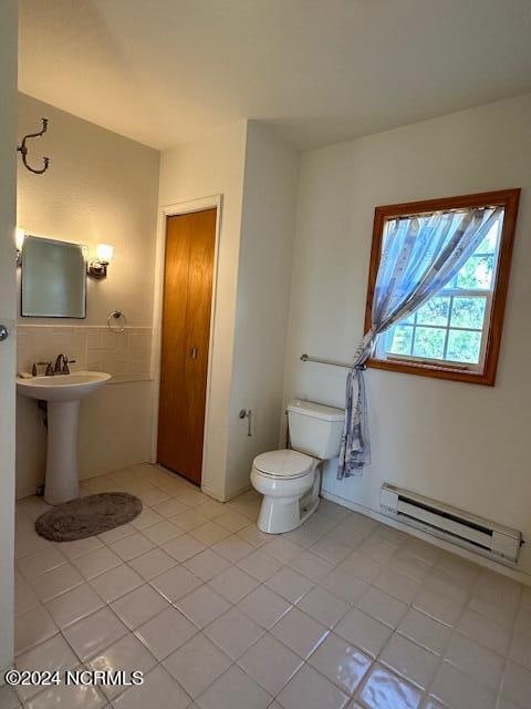 bathroom with tile patterned flooring, toilet, and a baseboard radiator