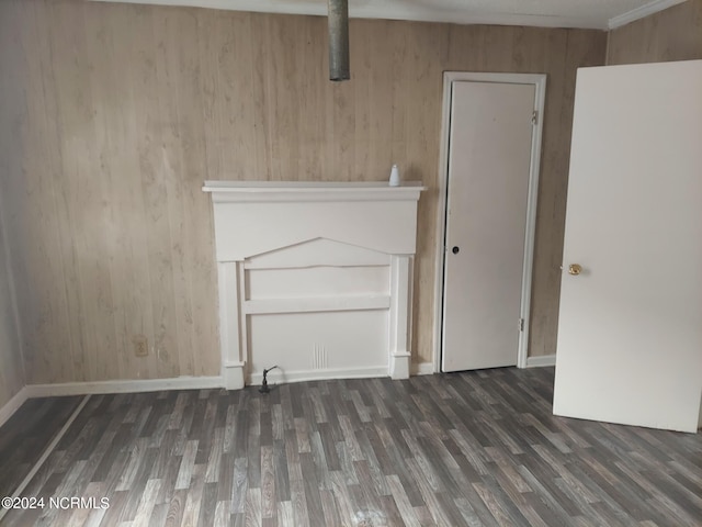 spare room featuring wooden walls and dark hardwood / wood-style floors