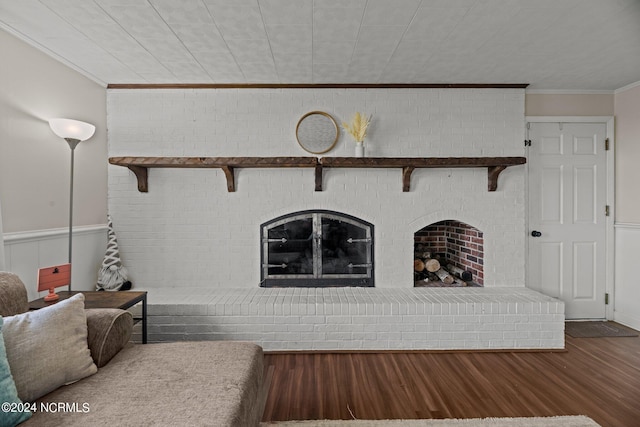 unfurnished living room featuring wood-type flooring, a fireplace, and crown molding