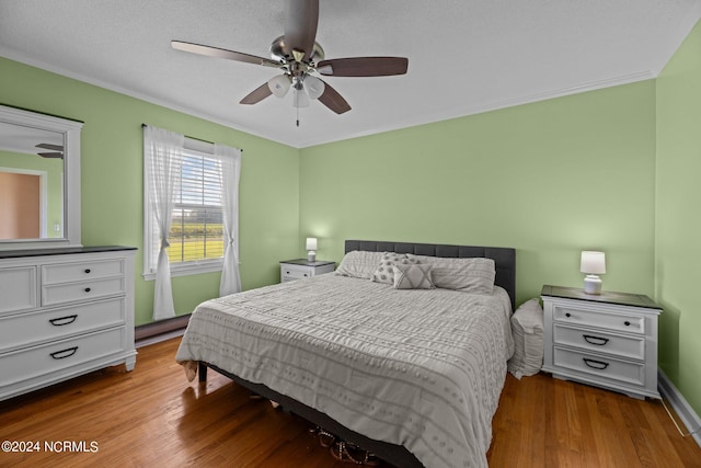 bedroom with a textured ceiling, ceiling fan, hardwood / wood-style floors, and crown molding