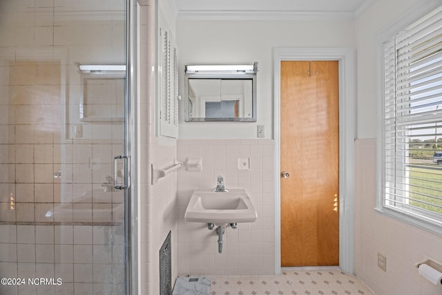 bathroom with crown molding, tile walls, sink, and an enclosed shower