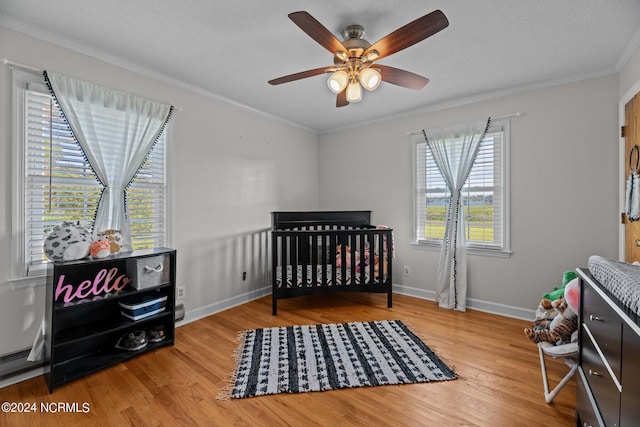 775 Gray Rd, Vanceboro, NC 28586 - bedroom featuring wood finished floors, crown molding, a crib, baseboards, and ceiling fan