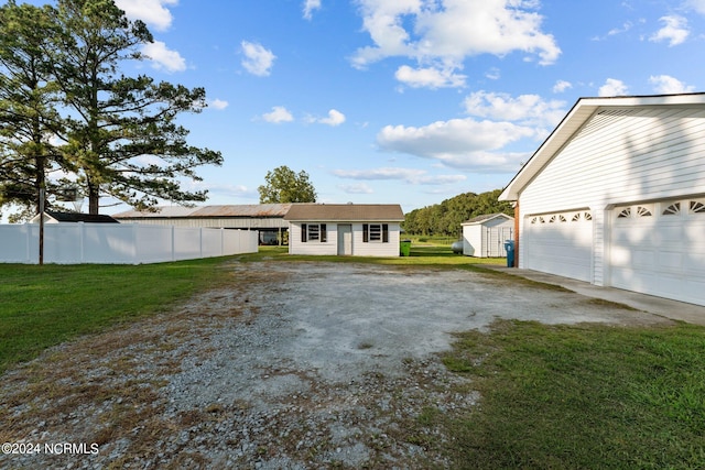 view of front facade with a garage, a front lawn, and a storage unit