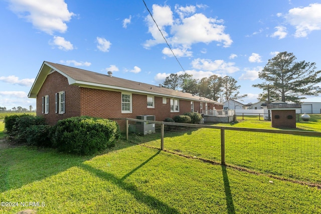 view of side of home featuring a storage shed and a yard