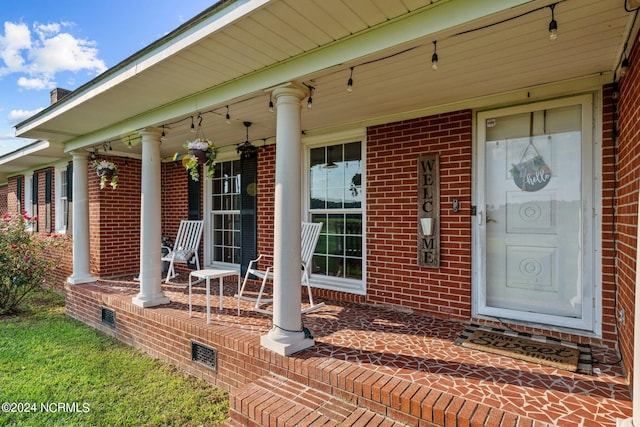 view of exterior entry featuring covered porch