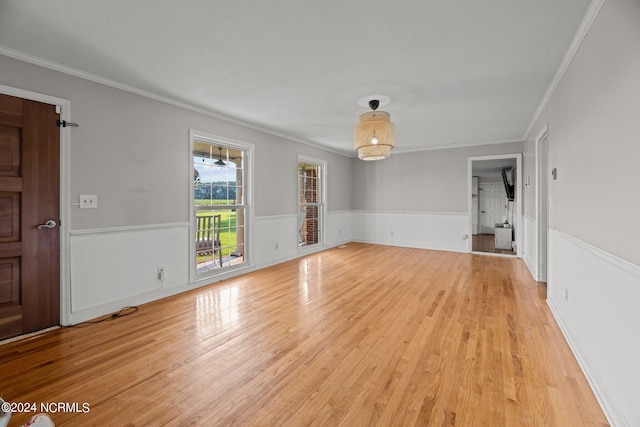 empty room featuring light hardwood / wood-style floors and ornamental molding