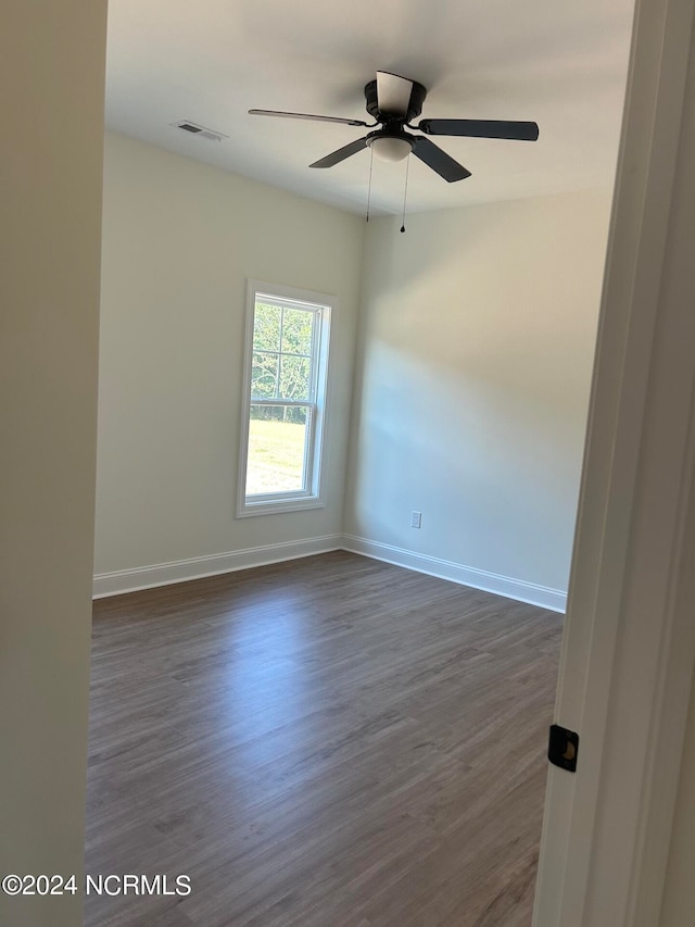 spare room featuring dark hardwood / wood-style flooring and ceiling fan