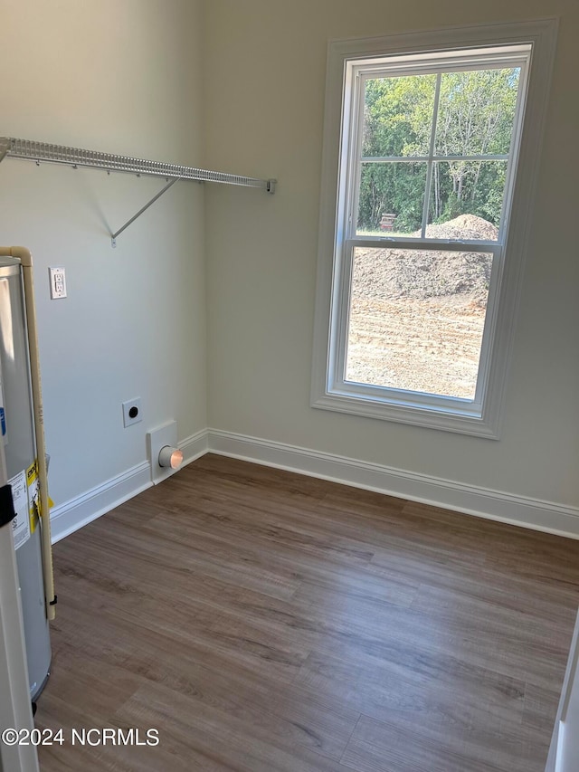 laundry area featuring electric dryer hookup, dark wood-type flooring, and electric water heater