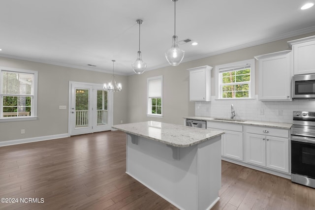 kitchen with stainless steel appliances, a sink, visible vents, a chandelier, and ornamental molding