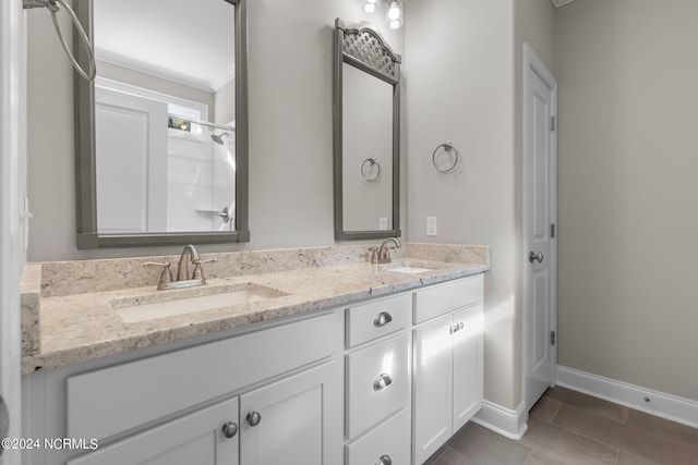 bathroom featuring double vanity, baseboards, ornamental molding, and a sink