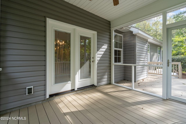 unfurnished sunroom with ceiling fan