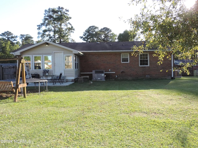 back of property with a lawn and a patio