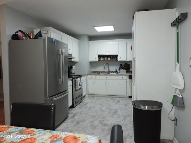 kitchen with appliances with stainless steel finishes, white cabinetry, and sink